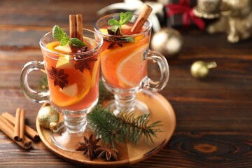Tasty punch drink and spices on wooden table, closeup. Christmas season