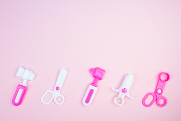 The concept of a pediatrician. Pediatrics. Toy medical devices on a pink background. Children play professional doctor. Choice of profession. Get vaccinated.