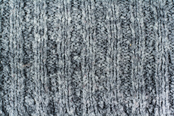 Sweater or scarf fabric texture large knitting. Knitted jersey background with a relief pattern. Braids in knitting . Wool hand- machine, handmade