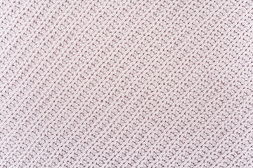Sweater or scarf fabric texture large knitting. Knitted jersey background with a relief pattern. Wool hand- machine, handmade.
