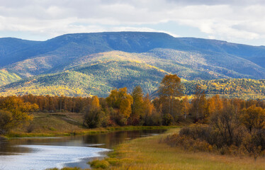 Autumn landscape with mountains and a river. Russia. Siberia