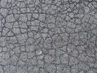 Cracked asphalt texture showing road surface damage and deterioration
