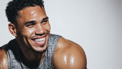 Close-up portrait of a happy and athletic young man, drenched in sweat after an intense workout, radiating a triumphant smile that reflects his dedication to fitness and a healthy lifestyle