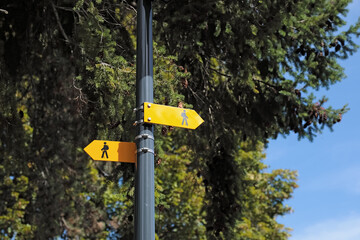 These are yellow directional signs in Le Grand Saconnex, Switzerland, that indicate walking trails