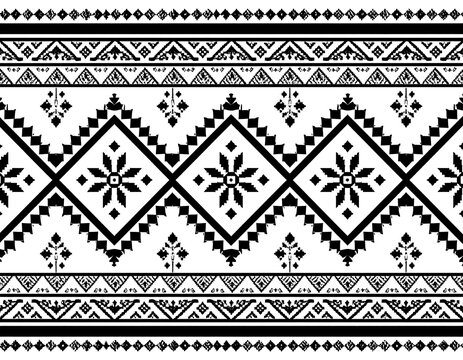 Intricate geometric pattern featuring alternating diamond shapes with floral accents and zig-zag elements, presented in black and white