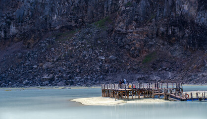 Ethereal landscape of Kawah Putih, a stunning volcanic crater lake with turquoise waters and stark, barren trees, creating a unique and otherworldly scene in West Java, Indonesia. Beautiful burred
