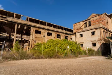 Selbstklebende Fototapeten Mediterranes Europa Sardinia, Italy: Abandoned Industrial Building Ruins in Southern Europe on a Sunny Day: Deterioration, Urban Decay, and Economic Decline  © marekfromrzeszow
