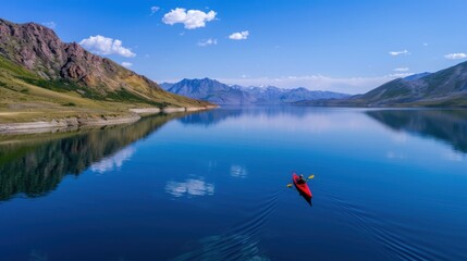 Serene Kayaking Adventure in Tranquil Lake Surrounded by Majestic Mountains and Clear Blue Sky