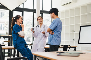 Young medical team discussing in bright office holding coffee, collaborative healthcare conversation and relaxed teamwork