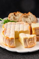 Washed rind cheese soft cheese with orange rind munster french cheese tasty snack fresh delicious gourmet food background on the table rustic top view copy space
