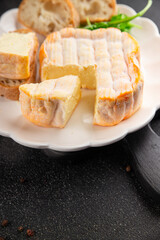 Washed rind cheese soft cheese with orange rind munster french cheese tasty snack fresh delicious gourmet food background on the table rustic top view copy space