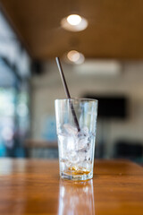 A little ice left in glass on table after drink at cafe