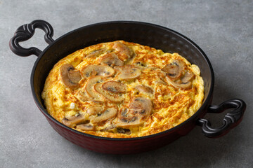 Frittata is an Italian type of omelet. Omelet with mushrooms cast-iron pan.