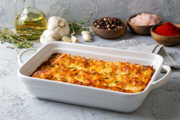 Potato gratin - graten (baked potatoes with cream and cheese) with rosemary and forks (Turkish name; Kremali patates)