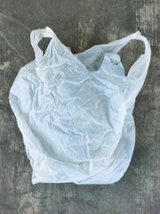 Portrait photo of translucent white plastic bags on the floor. Plastic waste.