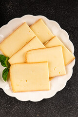 Raclette cheese portion slicing natural product tasty snack fresh delicious gourmet food background on the table rustic top view copy space