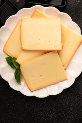 Raclette cheese portion slicing natural product tasty snack fresh delicious gourmet food background on the table rustic top view copy space