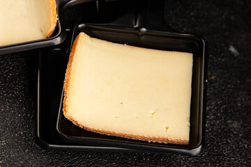 Raclette cheese portion slicing natural product tasty snack fresh delicious gourmet food background on the table rustic top view copy space
