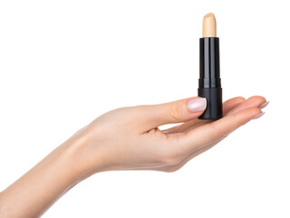 A hand gracefully holds a black lipstick tube with a nude shade against a dark background, showcasing beauty and elegance.