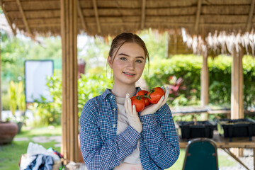 A young girl is showing off her homemade tomatoes.