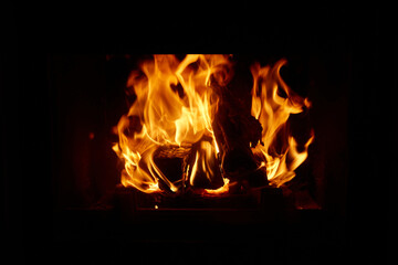 Flames dance in a cozy fireplace during a chilly evening at home with warm light filling the room