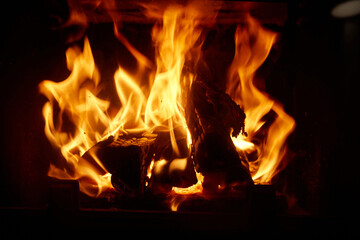 Flames dance and crackle while logs burn brightly in a cozy fireplace during a winter evening