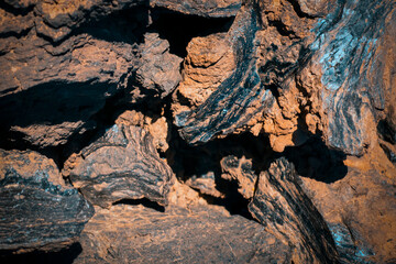 Lava formations, stones, black basalt in the rocks closeup on a volcano terrain.