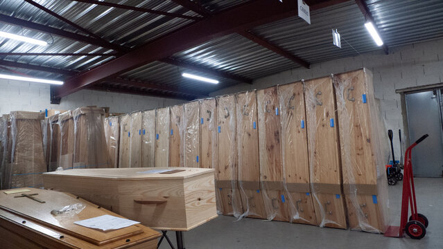 Les derniers voyages : rang&eacute;es de cercueils neufs.