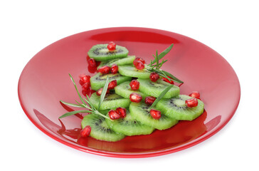 Christmas tree made of fresh slices of kiwi, rosemary and pomegranate seeds isolated on white