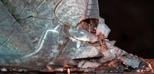 Broken glass closeup view on a dark background.