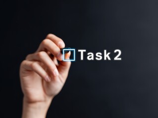 project management timeline tracking. A hand holding a pen near the text "Task 2" on a dark background.