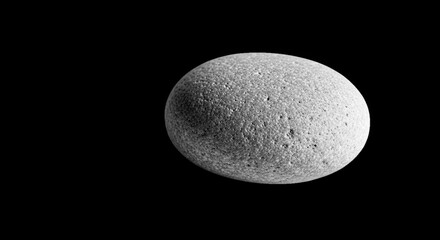 A textured sphere illuminated against a stark black backdrop, creating contrast