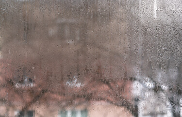Close-up of Wet Window with Droplets and Abstract Background