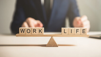 A balanced seesaw shows “WORK” and “LIFE”. work life balance concept