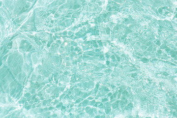 Blue water with ripples on the surface. Defocus blurred transparent blue colored clear calm water surface texture with splashes and bubbles. Water waves with shining pattern texture background.