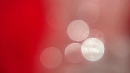 Soft red and pink blurred background with circular bokeh light patterns.
