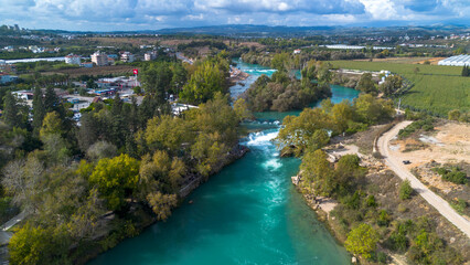 Manavgat Waterfall, Antalya. Stunning aerial view of Manavgat Waterfall with its vibrant turquoise waters and lush green vegetation. A breathtaking natural wonder from above.