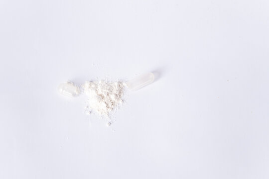 Open capsule with lactobacilli or probiotics on a white background. There is space for text.