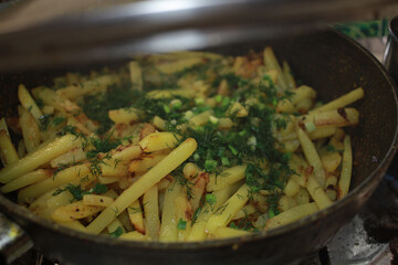 Appetizing and delicious fried potatoes in a pan with herbs