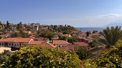Naklejka premium Panoramic view of Kaleici old town in Antalya featuring traditional houses with characteristic terracotta tile roofs overlooking the bright Mediterranean Sea