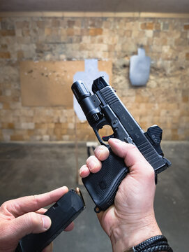 Baltics, November 1, 2025: First-Person View (POV) Tactical Shooting: Reloading a Customized Glock 19 with Tactical Equipment (Red Dot Sight and Weapon Light) at an Indoor Range