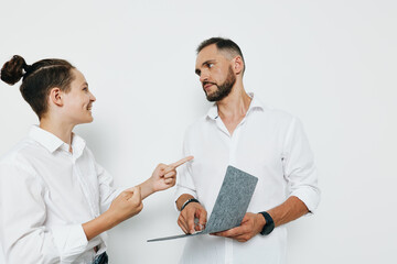 Obraz premium A professional man in a white shirt stands against an isolated colored background, exuding confidence and focus as he discusses work, showing calm determination and engaged curiosity.