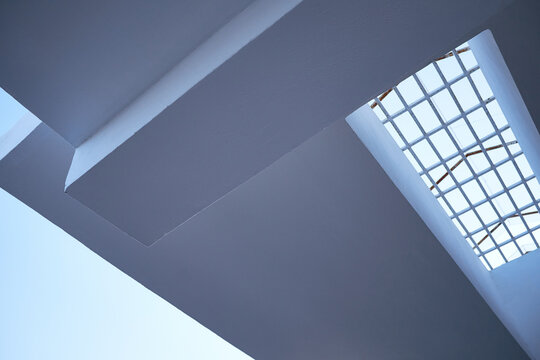 Low angle view of cloudless sunny sky seen through metal grid on white porch ceiling