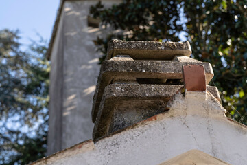 Weathered concrete chimney on rooftop against clear sky