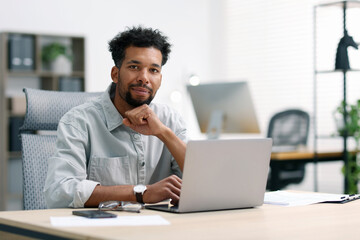 Man working on laptop at table in office