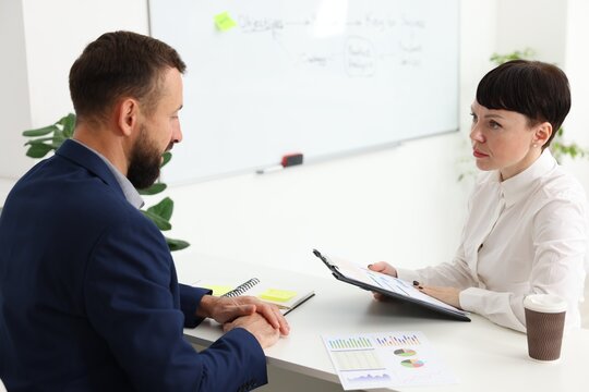 Business process. Colleagues working together at desk in office - Powered by Adobe