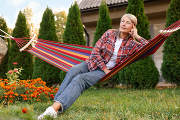 Beautiful senior woman resting in hammock outdoors