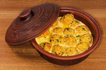 Baked and stewed salmon patties in partially open clay roaster