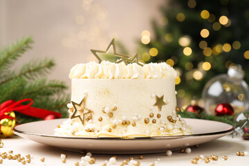 Delicious cake with Christmas decor on white table against blurred lights, closeup