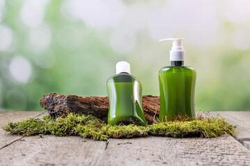 containers for skin care products on a wooden background surrounded by moss
